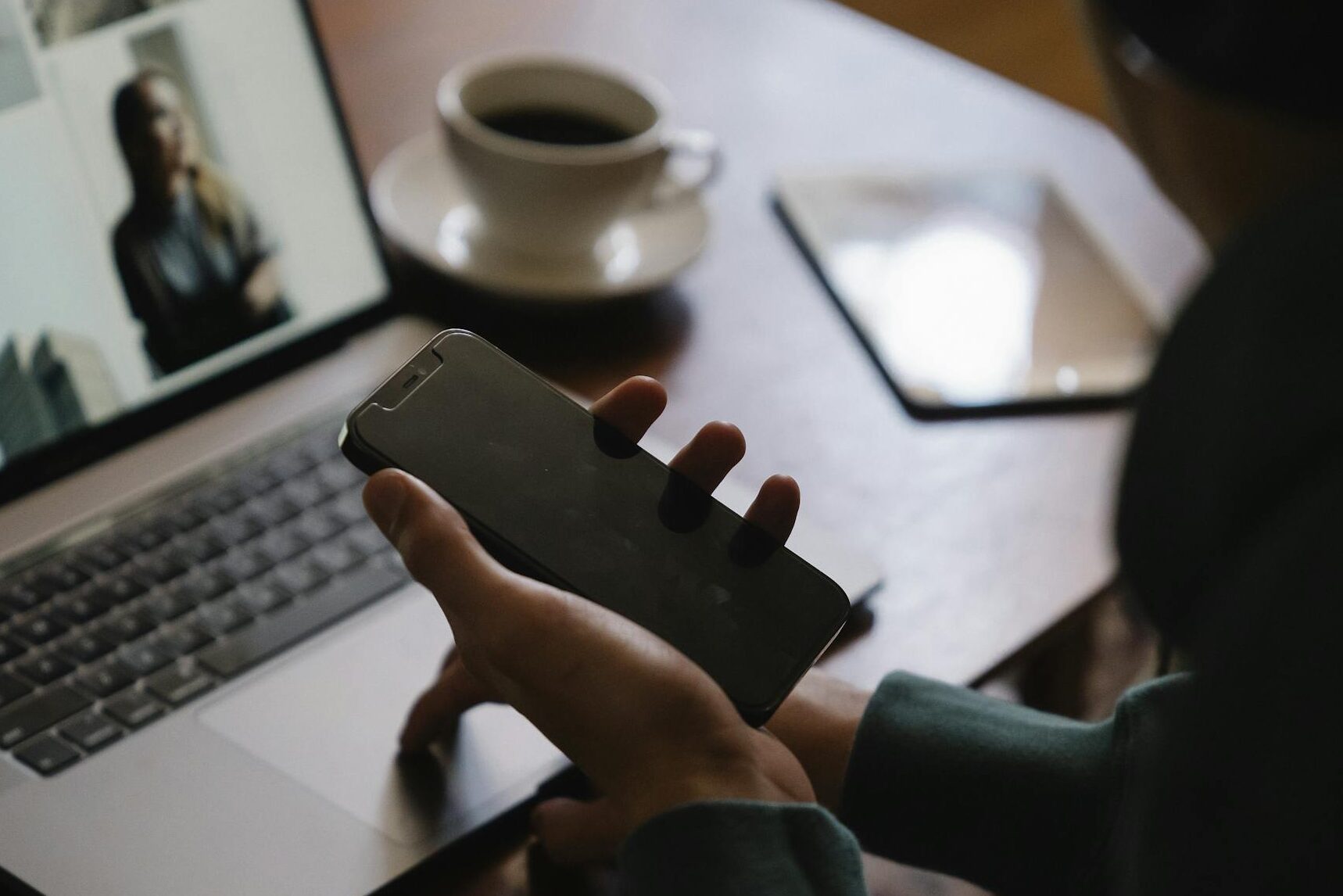 Man using laptop and smartphone at workplace